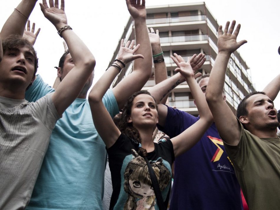 Los manifestantes muestras su pacifismo a los efectivos de policía que controlavan la concentración y manifestación en solidaridad con los desalojadas en Barcelona que tuvo lugar en Valencia.